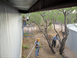 Workers installing PVC pipe under the gutters.